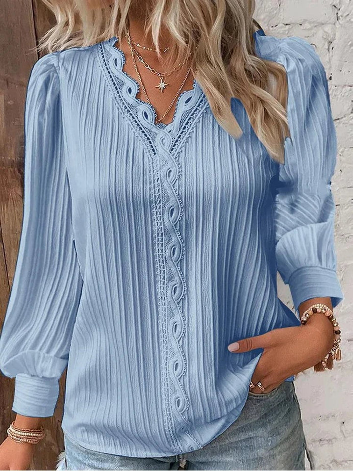 Close-up of lace accent trim along the neckline of a white chiffon blouse