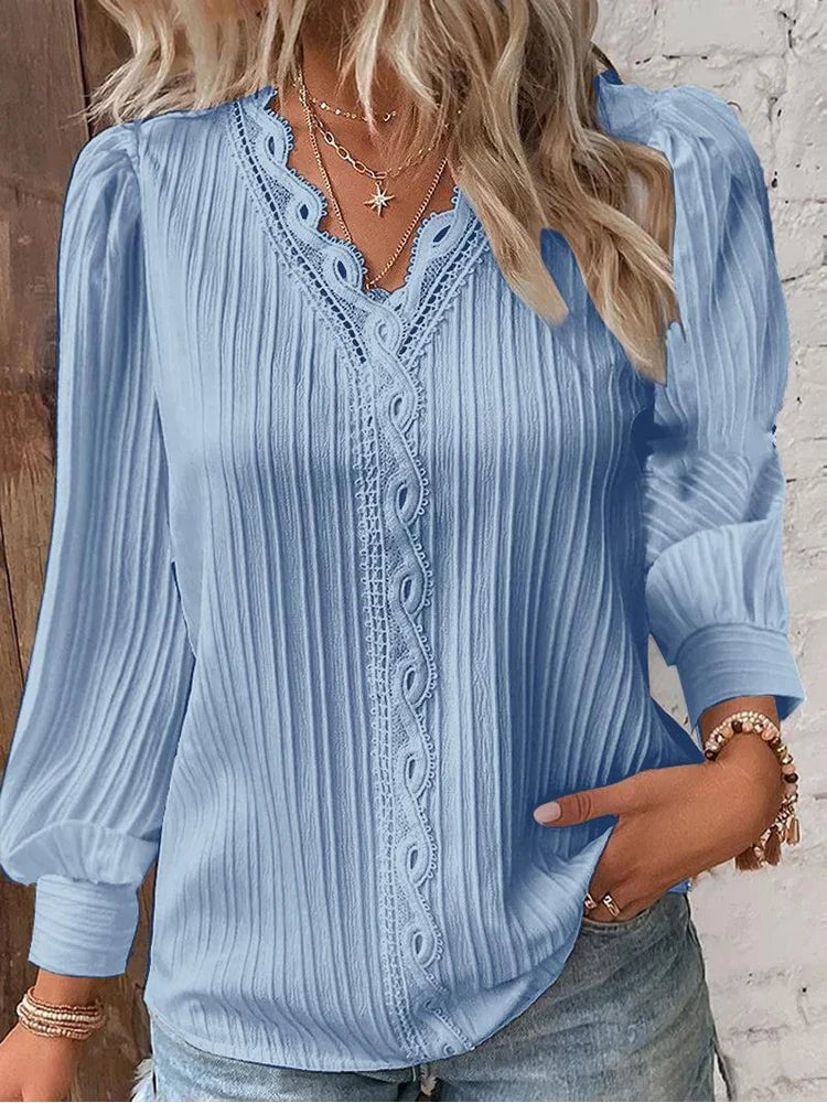 Close-up of lace accent trim along the neckline of a white chiffon blouse