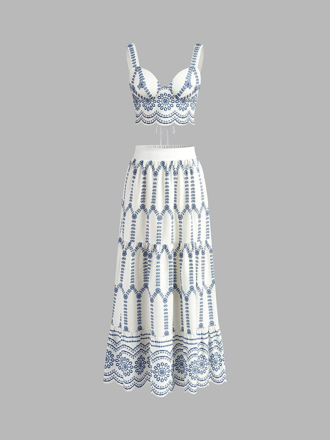 Front view of blue and white embroidered crop top and tiered maxi skirt co-ord set on a model