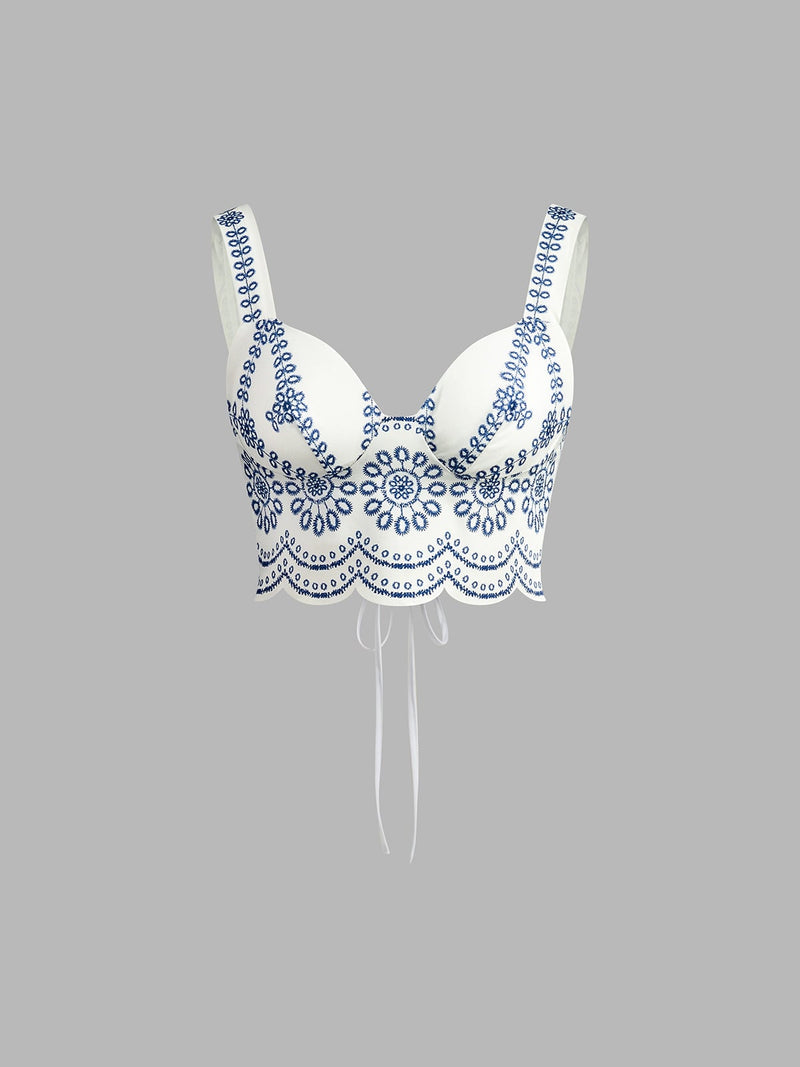 Close-up of intricate blue floral embroidery and scalloped hem on the crop top