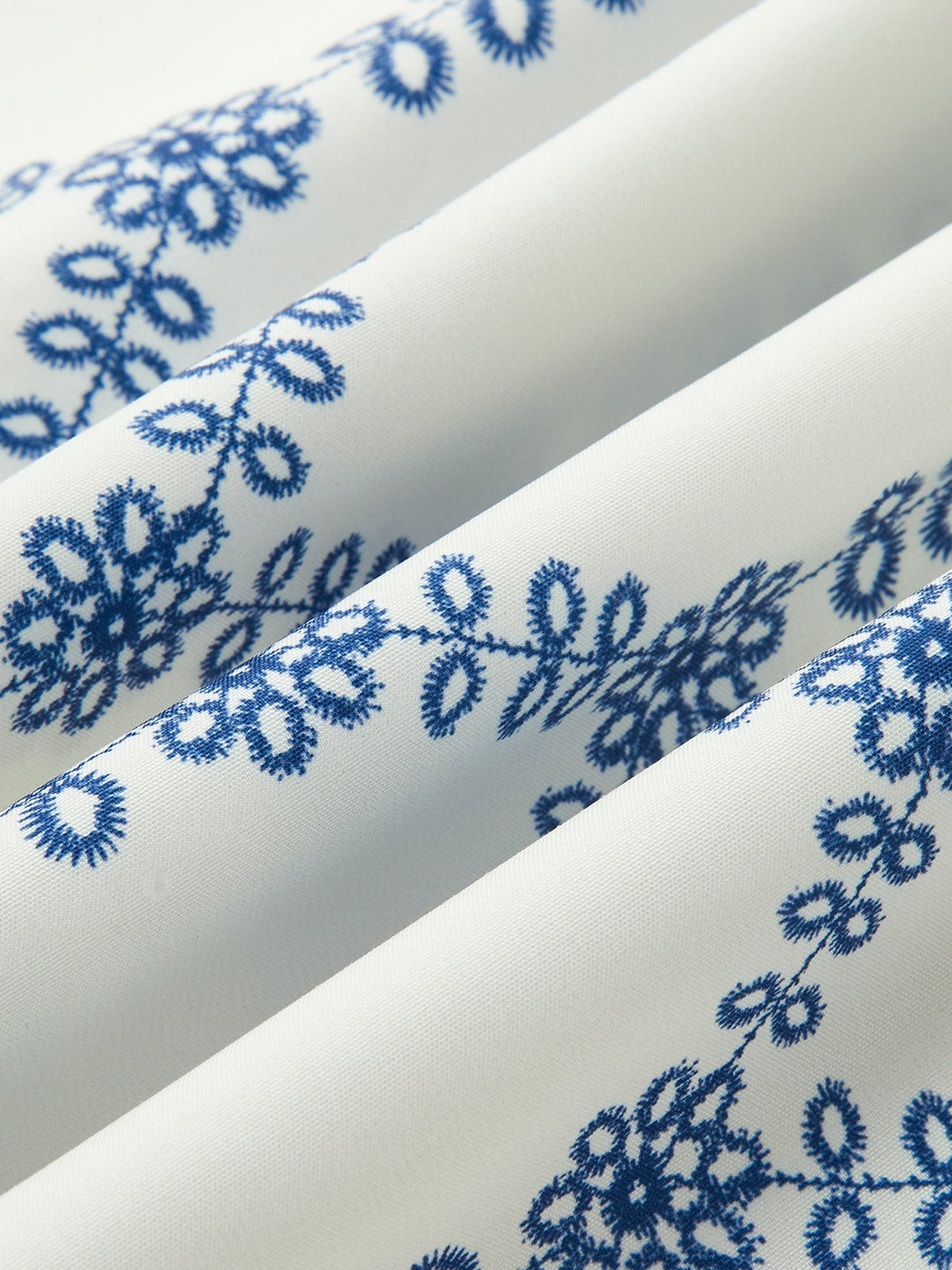 Detail shot of the matching blue embroidery on the maxi skirt hem