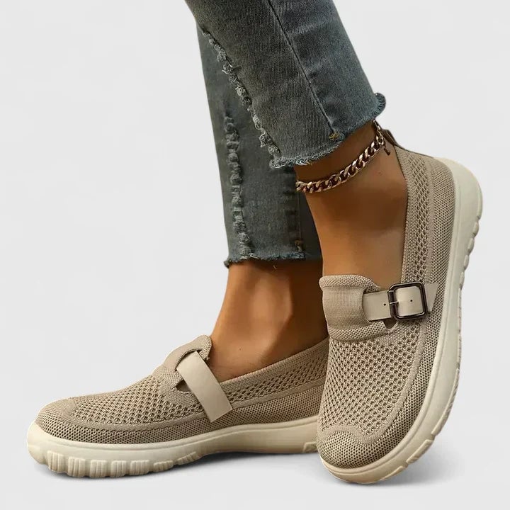 Women's beige perforated mesh slip-on sneaker with buckle strap accent and chunky cream rubber cupsole, side view