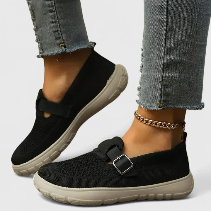 Pair of Sara mesh slip-on sneakers in black colorway displayed on a clean neutral background