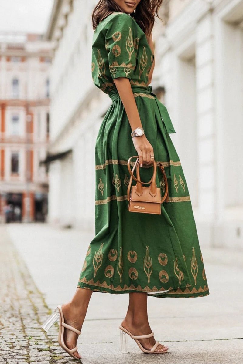 Woman styling the Savannah midi dress in green with strappy sandals for a casual summer look