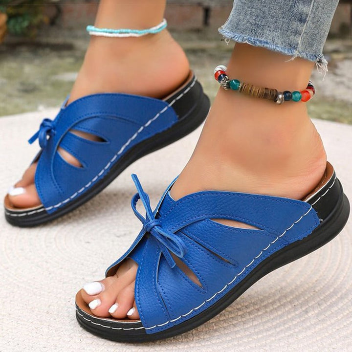 Model wearing Scarlett sandals in dark blue, close-up of feet showing fit and comfort