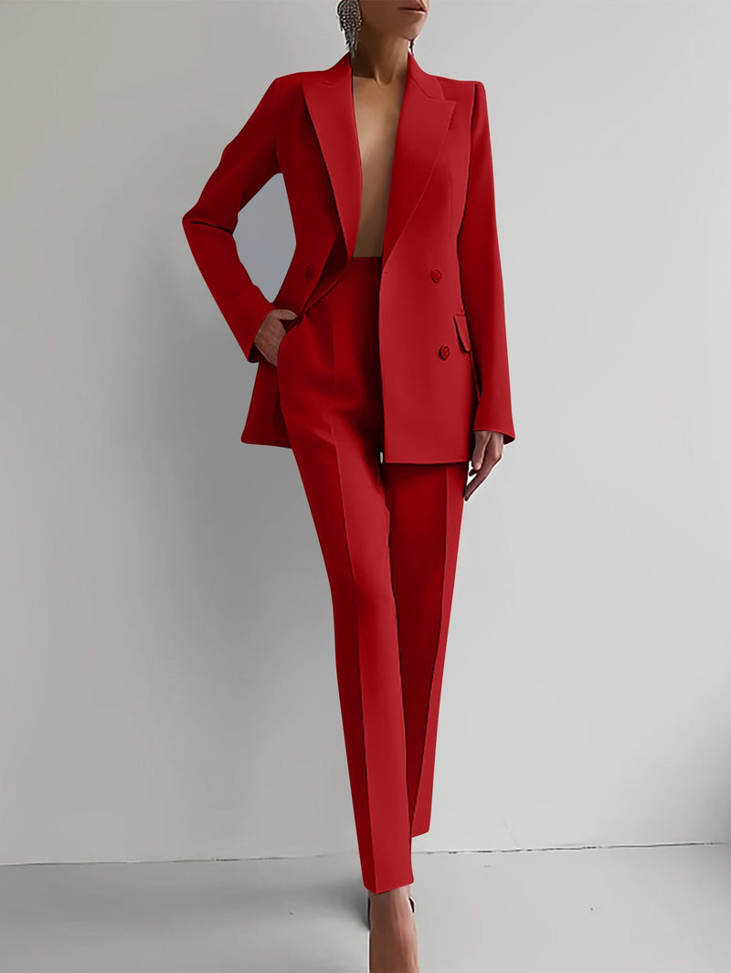 Woman wearing a bold red double-breasted peaked lapel blazer and slim straight-leg trousers suit set