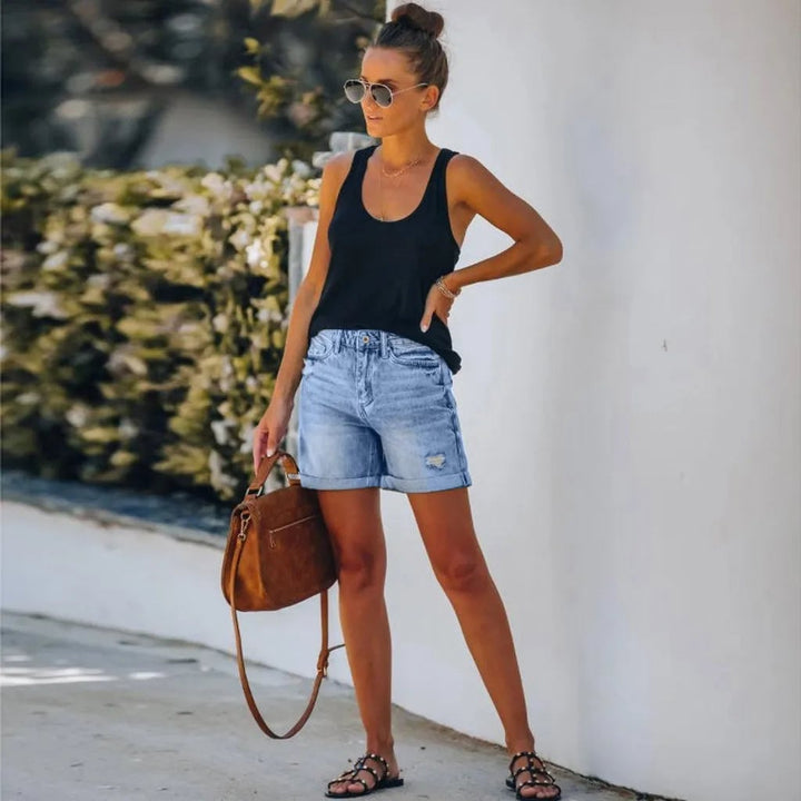 Front view of Scout high-waist light wash distressed denim shorts with rolled cuff hem and button-fly closure