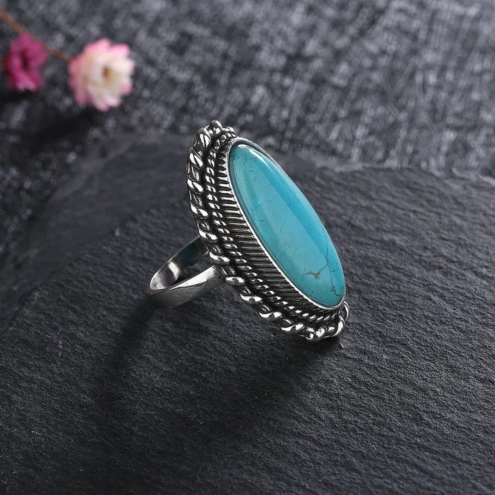 Model wearing the turquoise statement ring on one hand against a neutral background