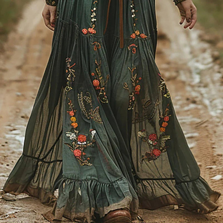 Model in dark brown bohemian floral maxi dress with pleated silhouette, full-length side view