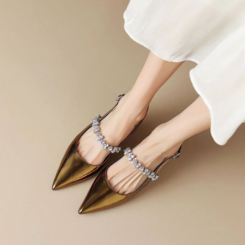 Pair of gold Seraphina slingback pumps on a neutral background