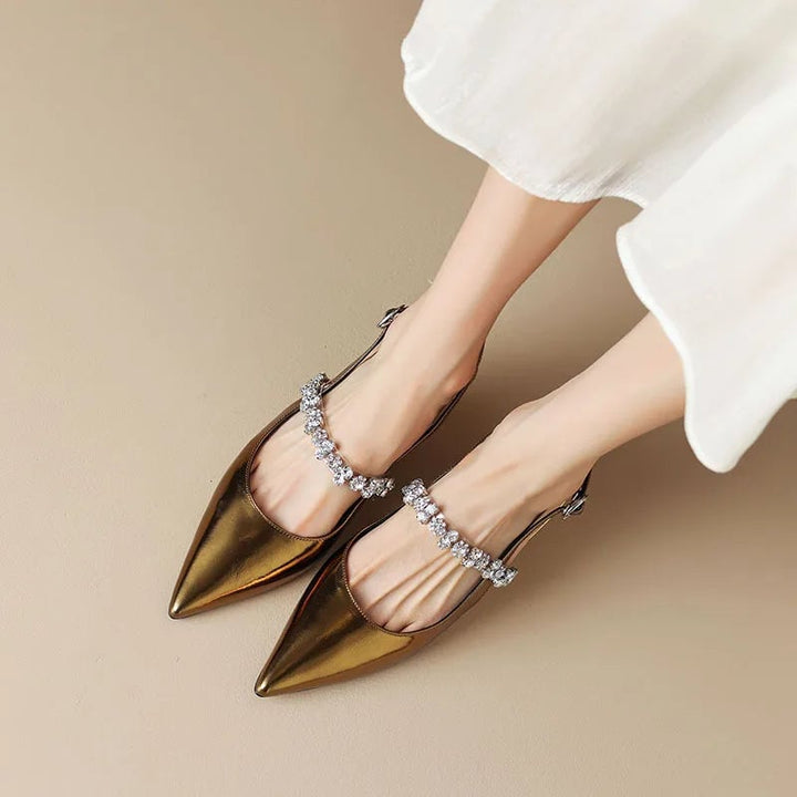 Pair of gold Seraphina slingback pumps on a neutral background