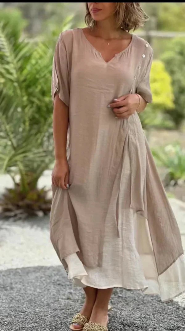 Woman wearing the Serena layered midi dress in khaki with a V-neck and asymmetric hem, styled with sandals