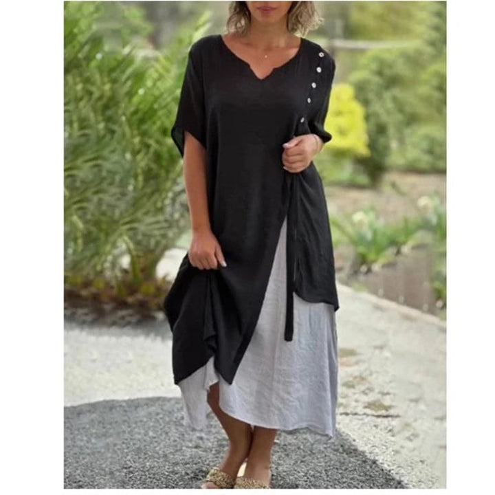 Close-up of the asymmetric layered hem and contrasting underlayer detail on the Serena midi dress in black
