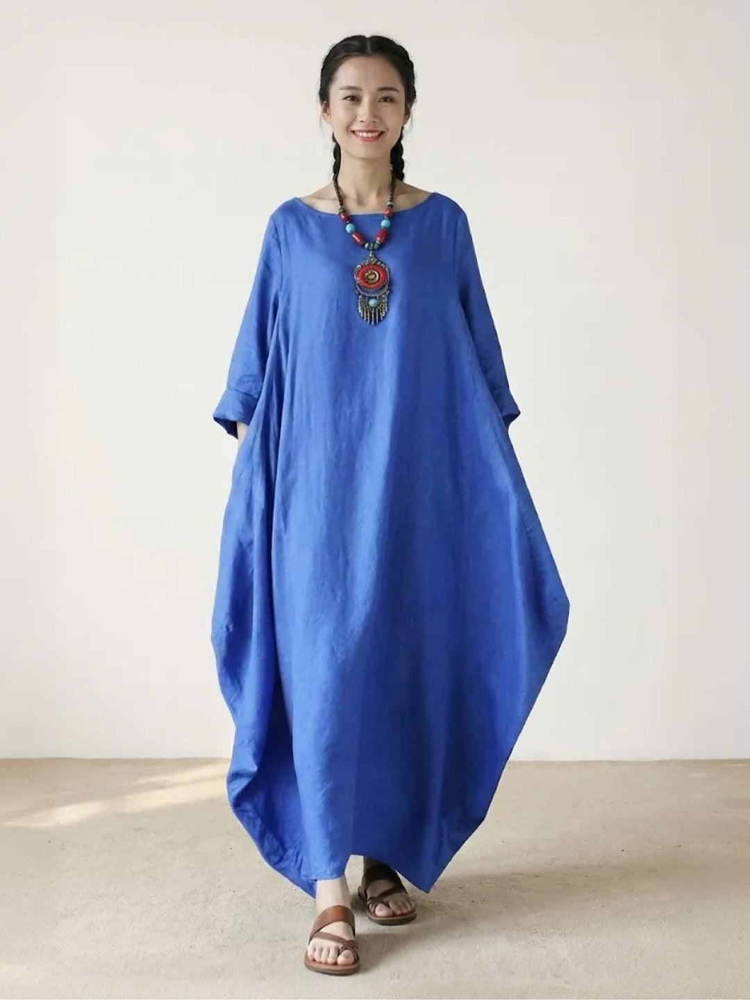 Woman wearing the Serena oversized boho maxi dress in Royal Blue with batwing 3/4 sleeves and floor-length hem, front view