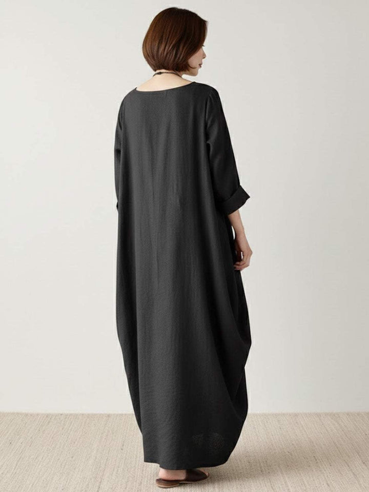 Close-up detail of the Serena maxi dress in Dark Green showing draped 3/4 sleeve