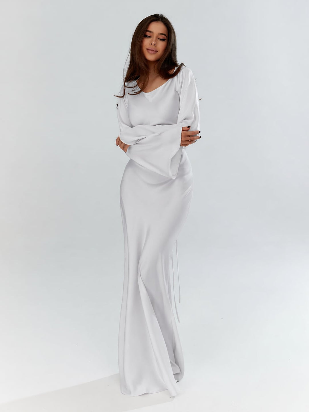 Woman wearing the Serena ivory satin long sleeve maxi gown, front view, floor-length silhouette