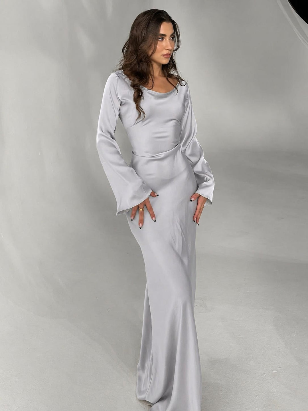 Three-quarter view of Serena black satin maxi dress showing refined tailored bodice
