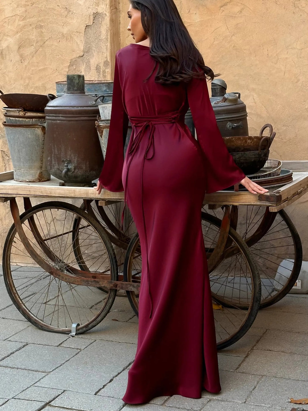 Lifestyle image of woman in Serena black satin formal gown at an evening event