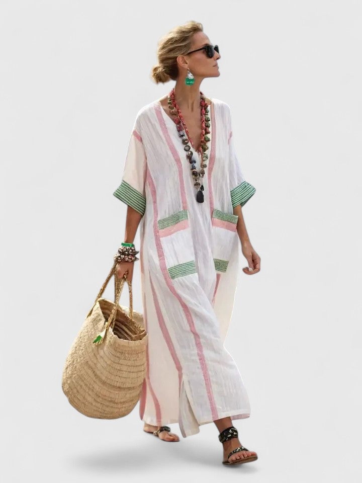 Woman in the Serena beige light blue kaftan maxi dress styled with flat sandals on a sunny day