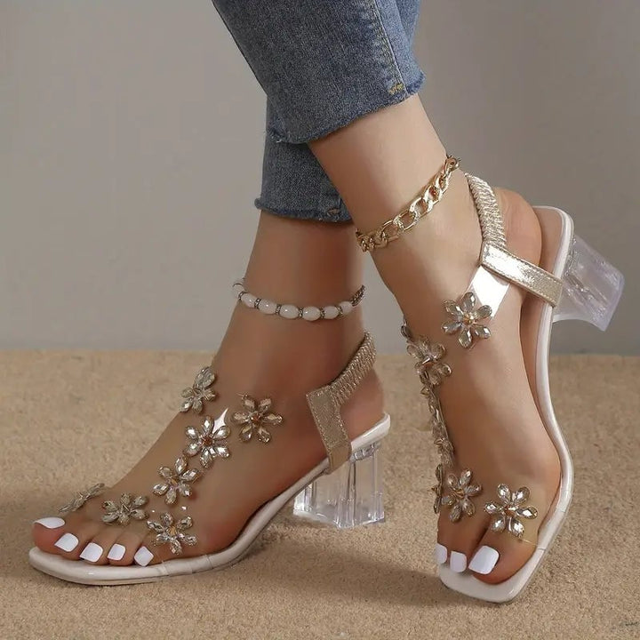 Model wearing Serene champagne golden rhinestone block heel sandals styled with an elegant dress