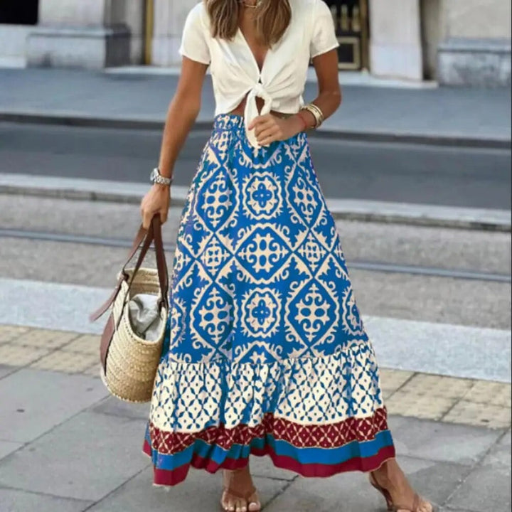 Blue boho maxi skirt with geometric floral print and high waist, shown on a model in a summer outdoor setting