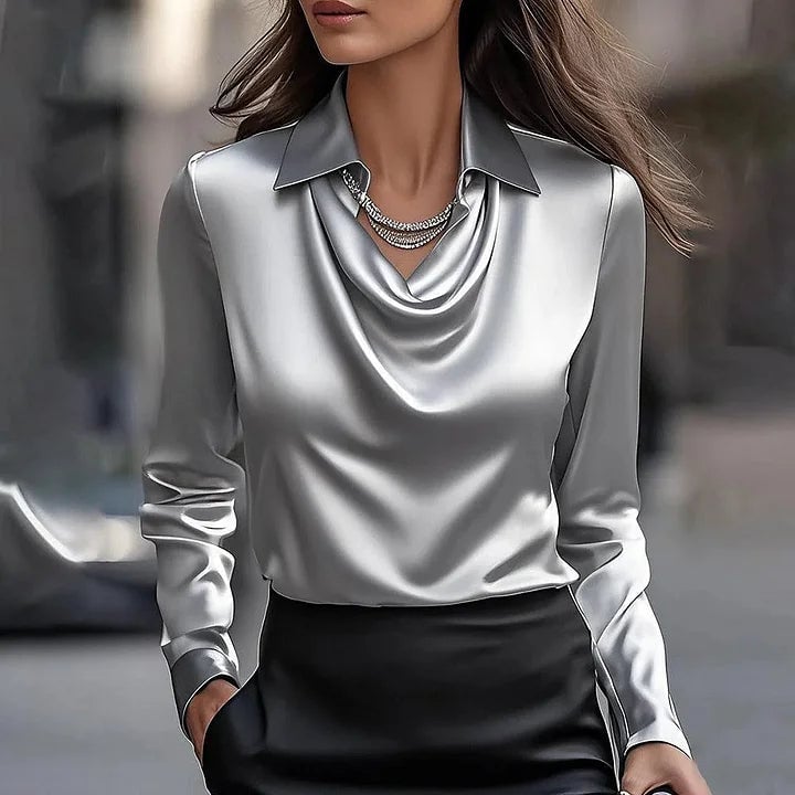 Woman in a blue floral print shiny V-neck blouse styled with tailored trousers