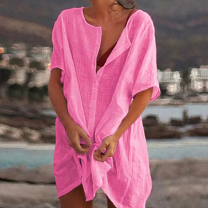 Close-up of the lightweight, breathable fabric and subtle button detail on a relaxed beach shirt dress in white