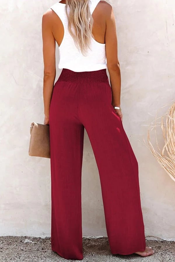 High-waisted trousers in wine red color with flowing fabric and timeless button accents