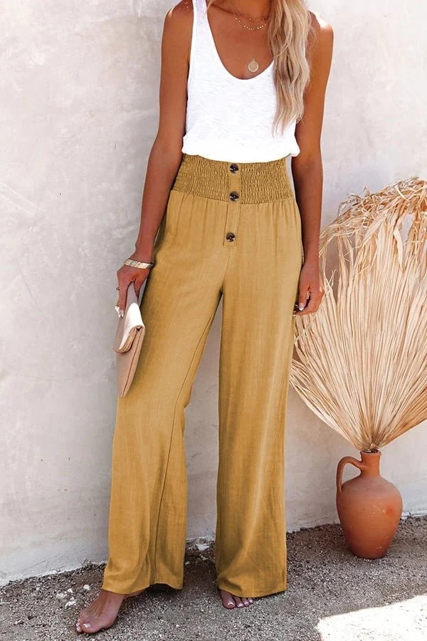 Black high-waisted trousers with button detail and smocked waistband on a standing model