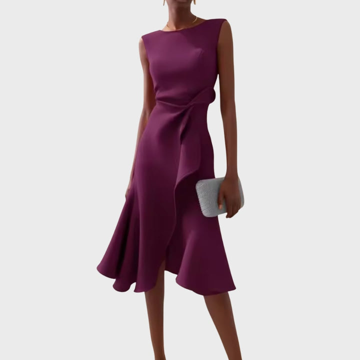 Model posing in the draped asymmetric midi dress at a styled event setting