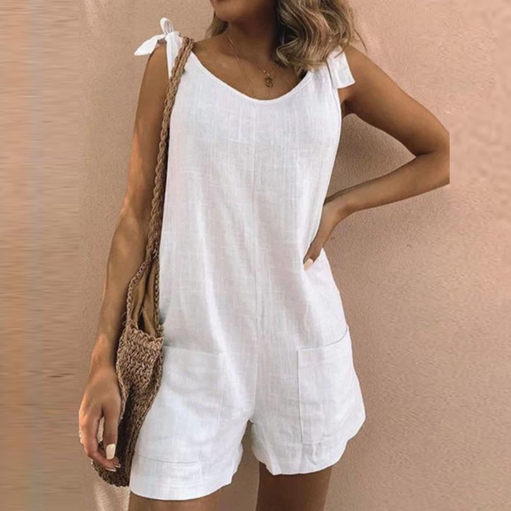 Woman wearing a white bow strap playsuit with side pockets, styled for a casual summer day