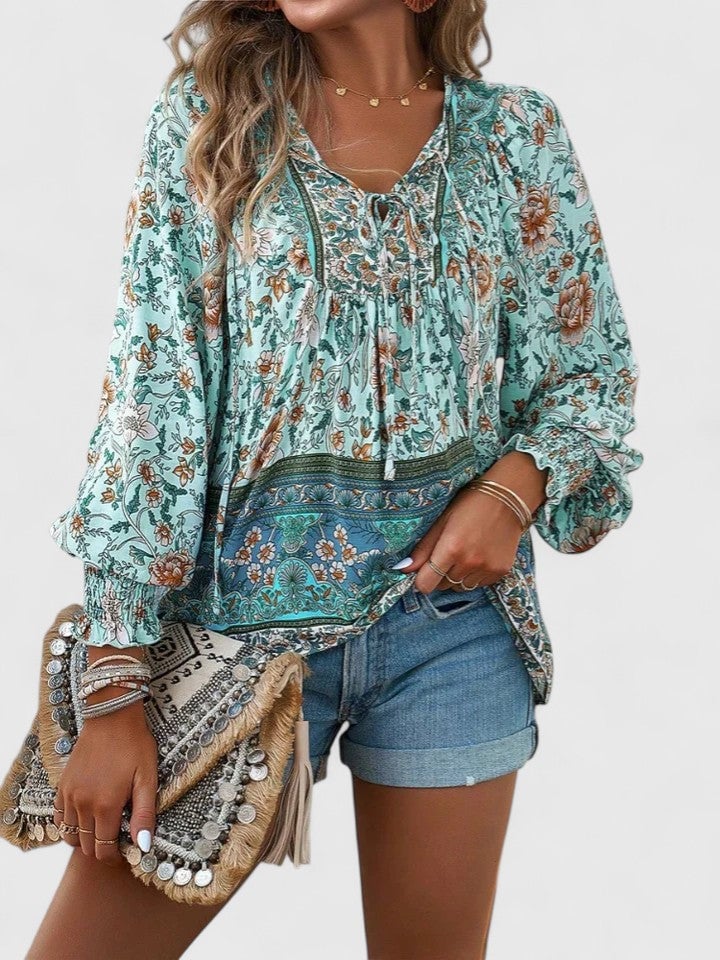 Model wearing the Sienna floral boho blouse in navy blue paired with light-wash jeans