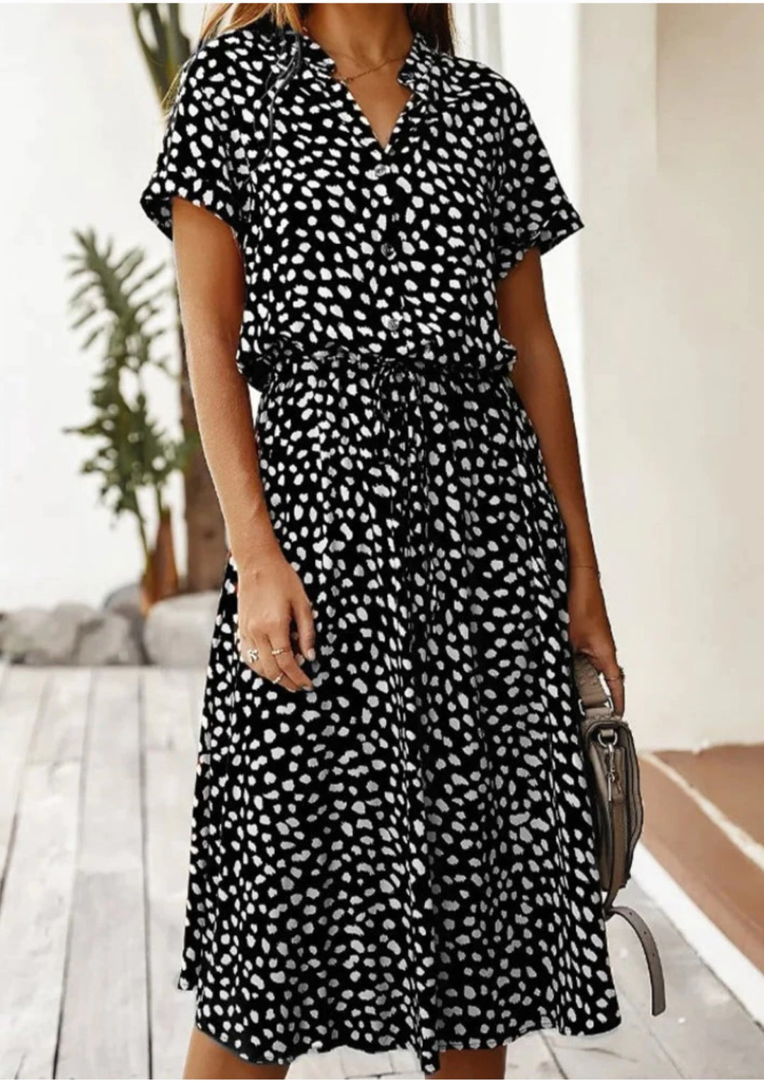 Back view of women's dalmatian-spot print midi dress in beige with flowy mid-calf skirt