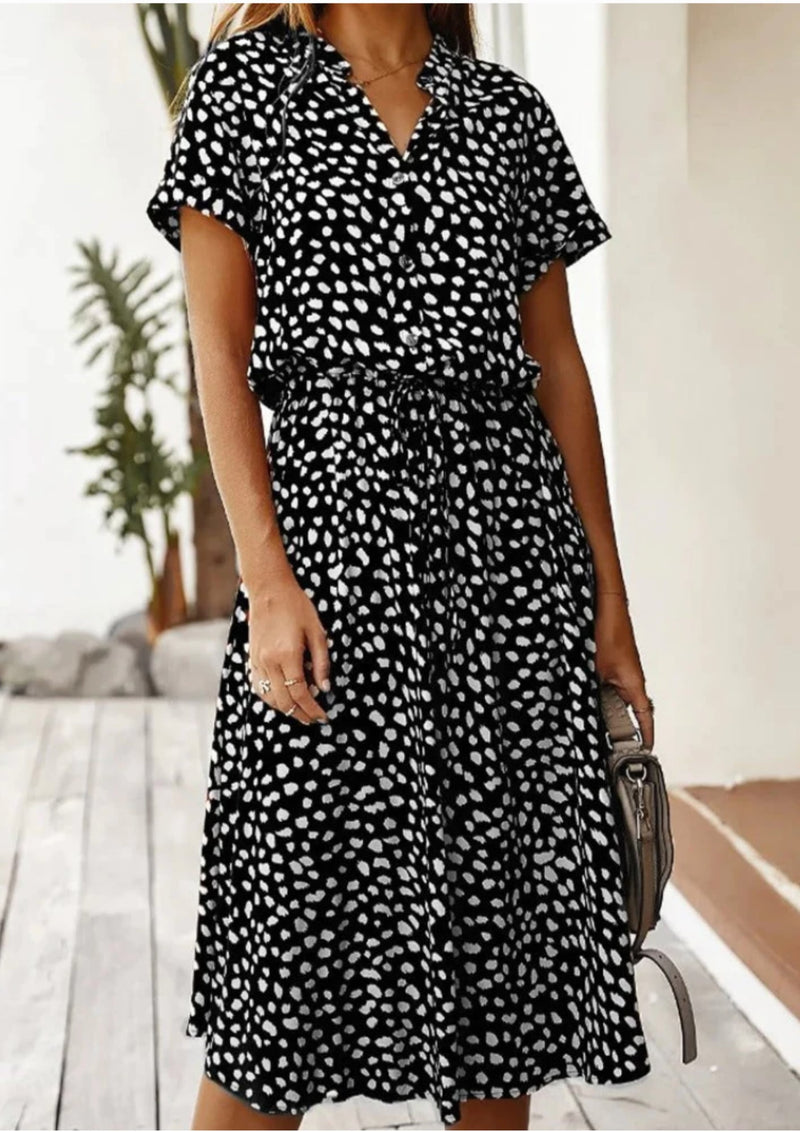 Back view of women's dalmatian-spot print midi dress in beige with flowy mid-calf skirt