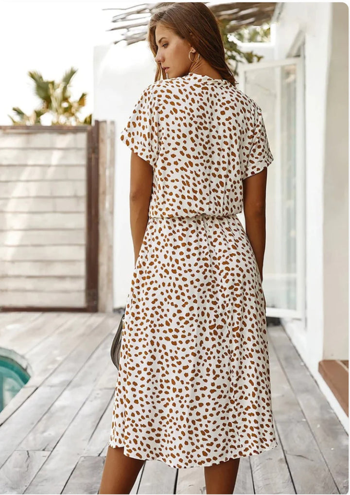 Detail shot of button placket and collar on orange-red spotted print midi dress