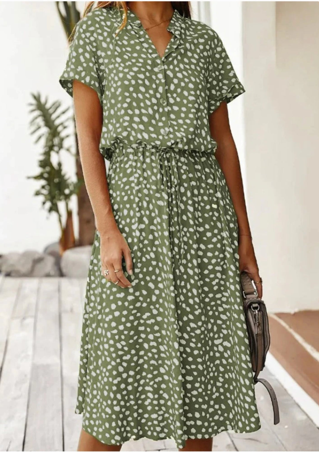 Full-length back view of spotted print midi dress in navy blue showing flowy midi hem