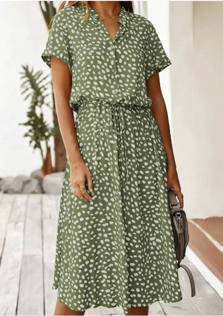 Full-length back view of spotted print midi dress in navy blue showing flowy midi hem
