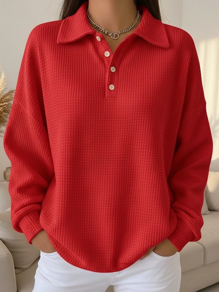 Woman wearing a red textured polo sweater with a crisp knit finish and polo collar, front view