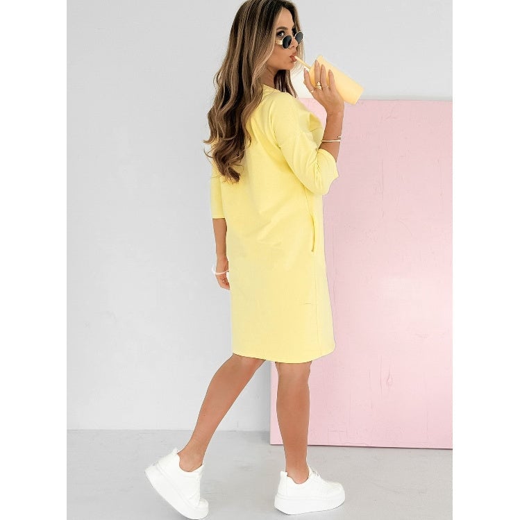 Full-length shot of the Skye sweatshirt mini dress in yellow styled for a casual everyday look