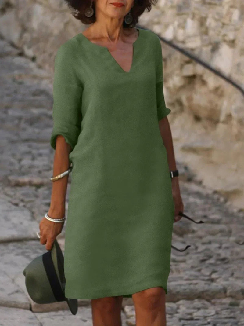 Close-up of the deep V-neckline and pleated bodice detail on an elegant dress