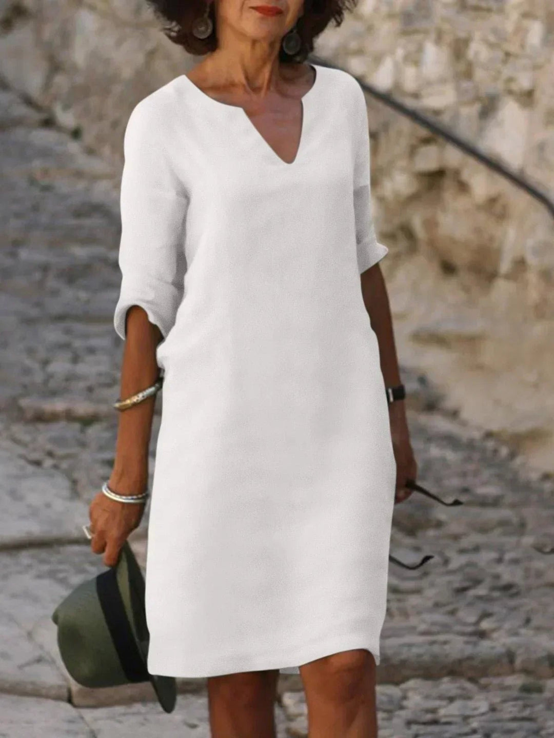 Orange V-neck dress with flowing skirt and structured bodice on a female model