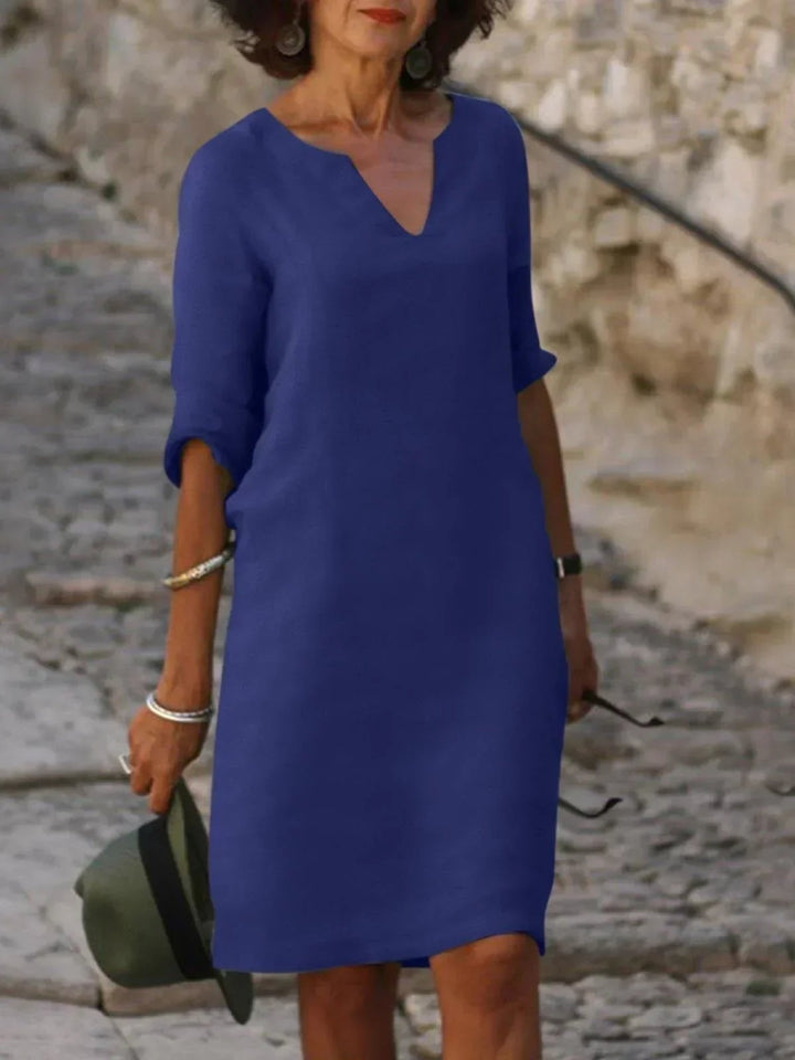 Back view of a green pleated V-neck dress with a polished, tailored silhouette