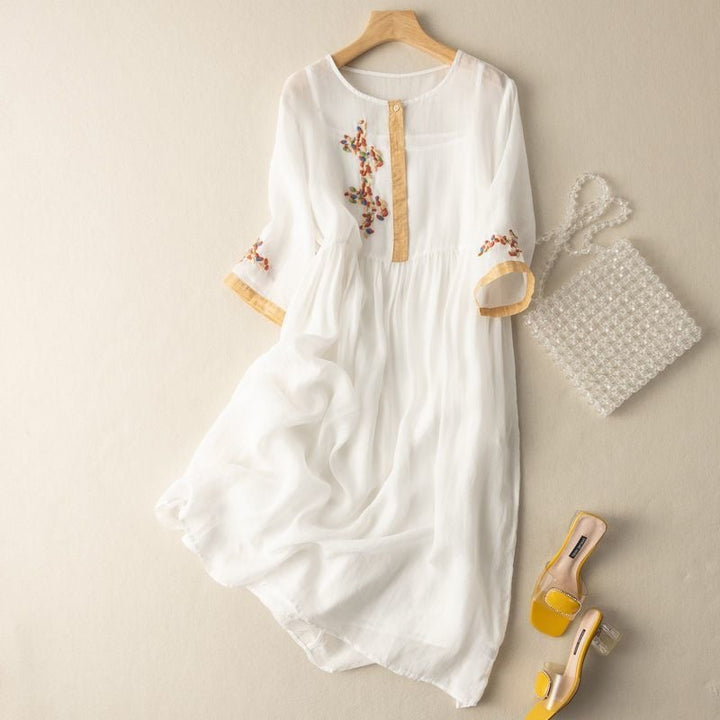 Close-up of delicate embroidery detail on the bodice and sleeves of a relaxed midi dress in a mustard pattern