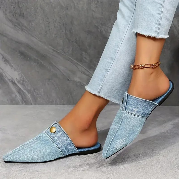 Close-up of gold-tone button accent on Sofia denim mule flat in blue