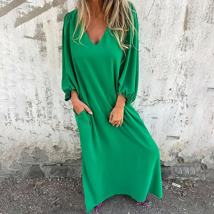 Close-up of the draped fabric and side slit detail on the flowing maxi dress
