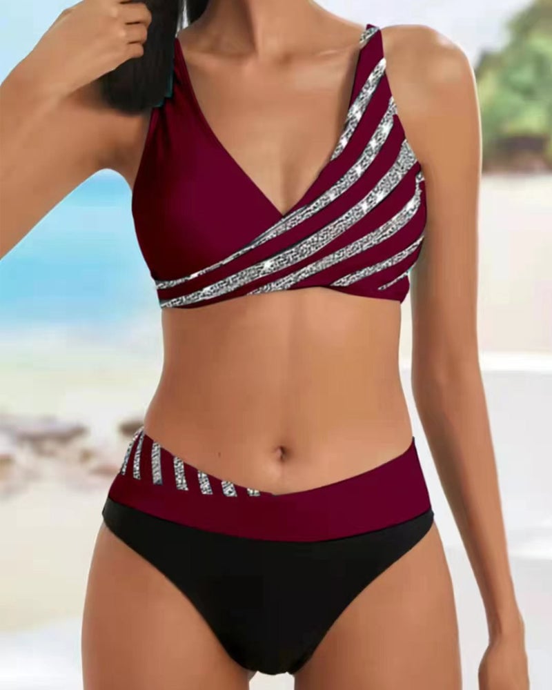 Model wearing the Solange bikini set in black styled with a flowing sarong on a sandy shore