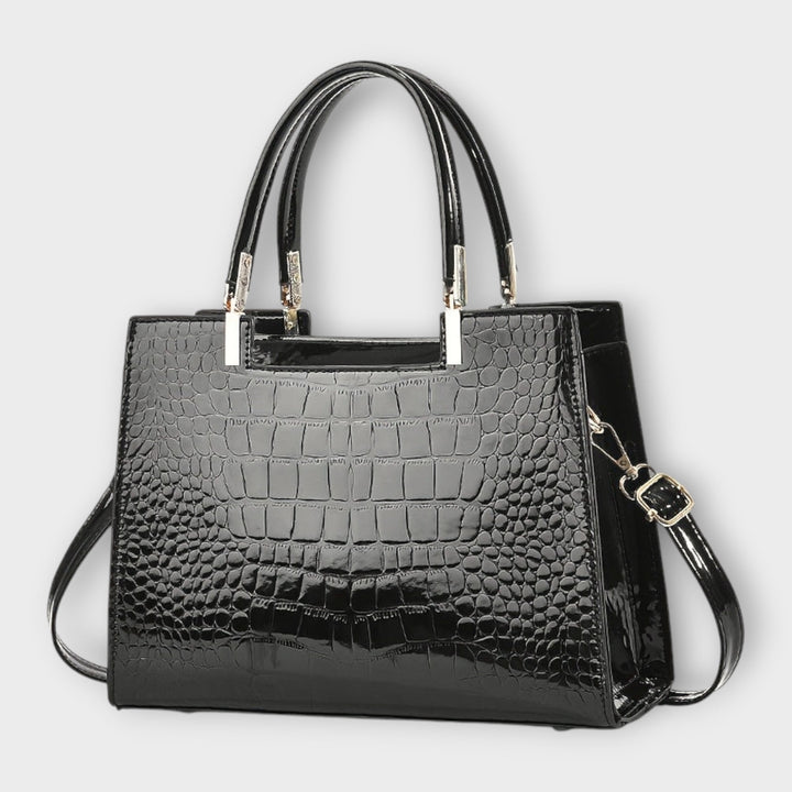 Close-up of Solveig handbag showing top handles and sleek exterior detail