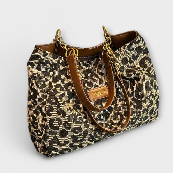 Leopard-print shoulder bag with top handle and adjustable strap, front view