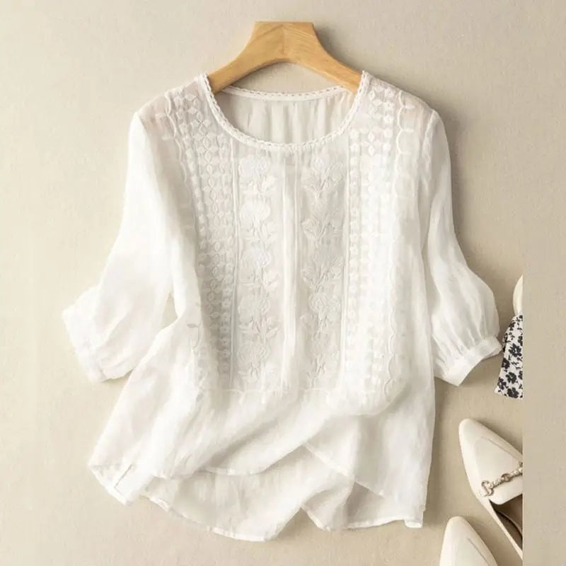 Woman wearing the Sonia floral relaxed blouse in a soft breezy fabric with delicate embroidered detailing at the neckline