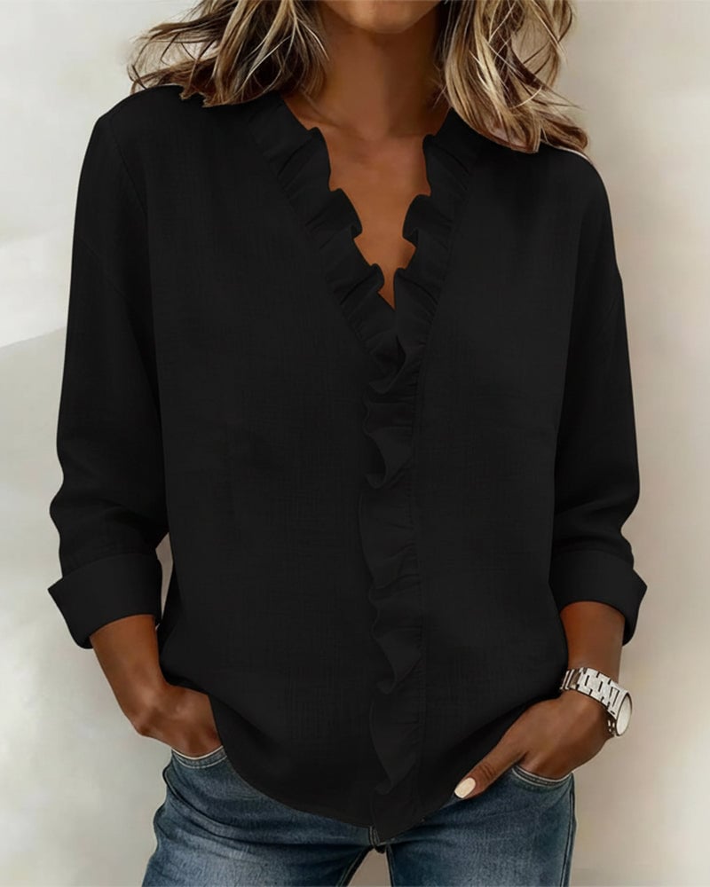 Woman wearing the Sophie ruffle blouse in pink styled with white trousers, side view
